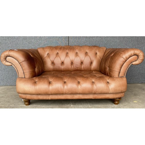 121 - A tan leather Chesterfield settee