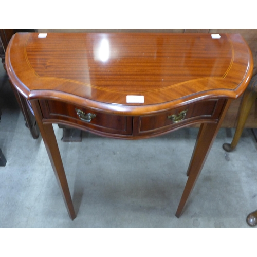 200 - A mahogany serpentine two drawer hall table