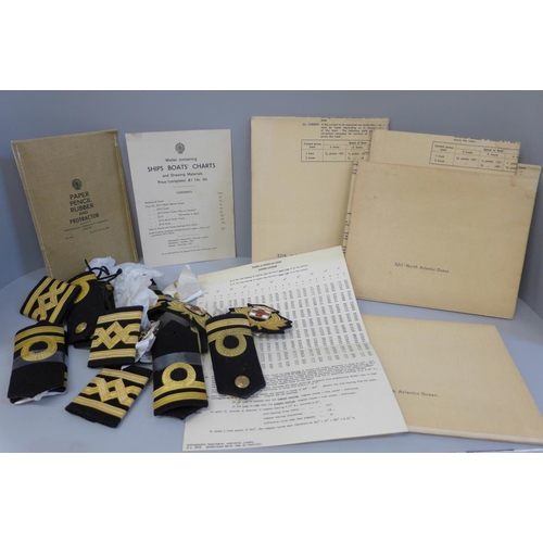 675 - A collection of Naval Officers' epaulettes, hat badges, buttons and Naval charts, 1950s