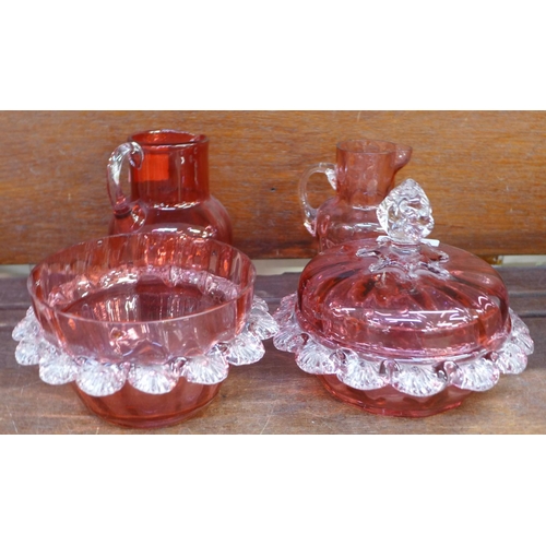 689 - Five items of cranberry glass; two jugs, two pots and a lidded pot, a/f