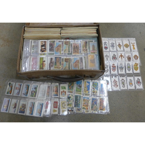 735 - Cigarette cards; a small suitcase of cigarette and trade cards in albums and sheets