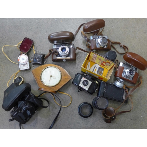 770 - A collection of vintage cameras and accessories: Voigtlander, Brownie, lens, light meter and a clock