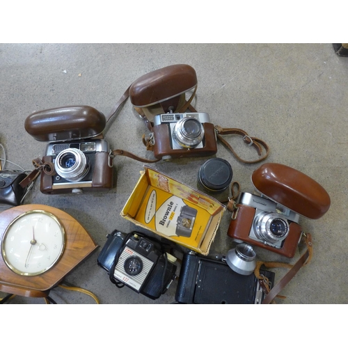 770 - A collection of vintage cameras and accessories: Voigtlander, Brownie, lens, light meter and a clock