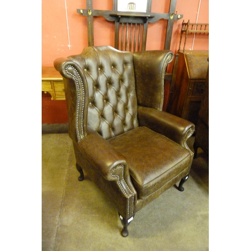 119B - A chestnut brown leather Chesterfield wingback armchair