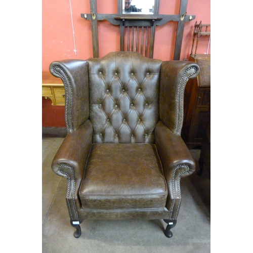 119B - A chestnut brown leather Chesterfield wingback armchair