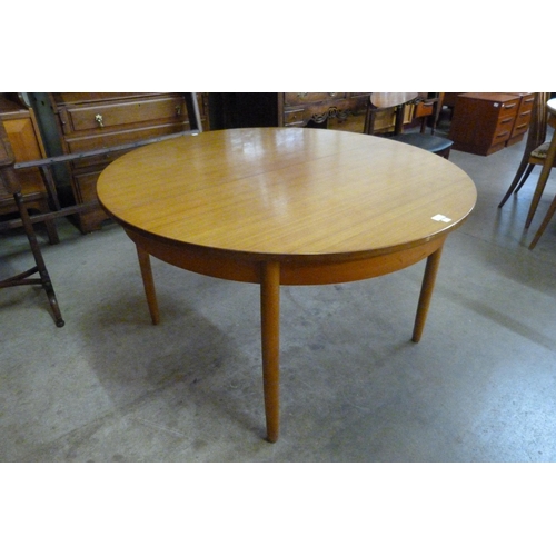 12 - A circular teak extending dining table