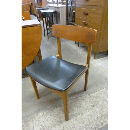 80 - A teak drop-leaf dining table and four chairs