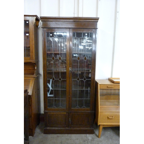 99 - An early 20th Century oak and stained glass two door bookcase