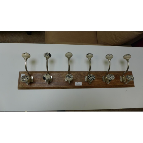 1417 - A six hook coat rack with patterned ceramic knobs