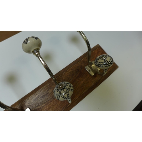 1417 - A six hook coat rack with patterned ceramic knobs