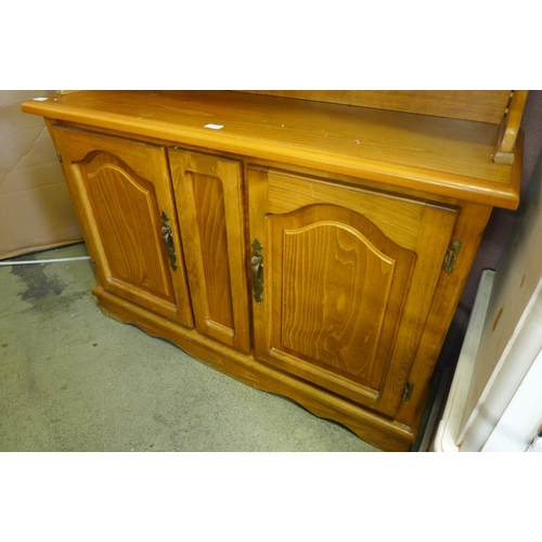 1570 - An oak effect four door wall unit