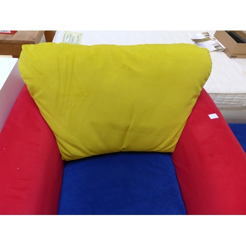 1612 - A red, blue and yellow upholstered armchair and ottoman footstool