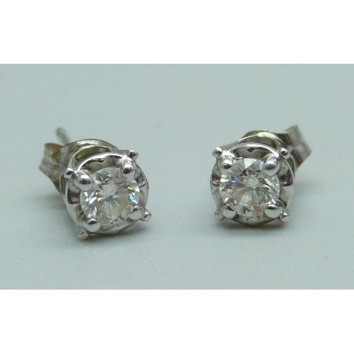 1021 - A pair of 14ct white gold and diamond stud earrings, 1g, (one butterfly fastener marked 375)