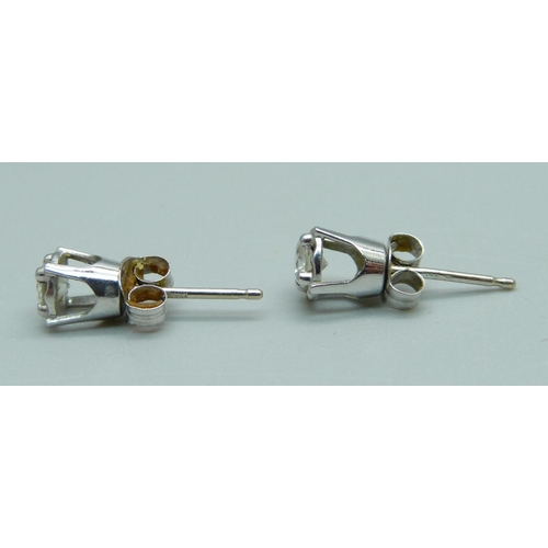 1021 - A pair of 14ct white gold and diamond stud earrings, 1g, (one butterfly fastener marked 375)