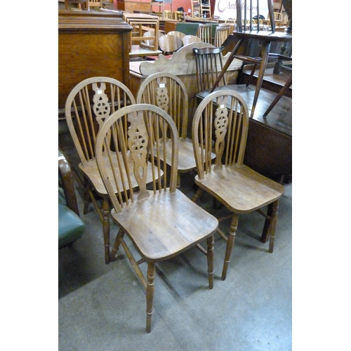 139 - A set of four elm and beech wheelback kitchen chairs