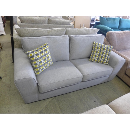 1601 - A grey upholstered three seater sofa with patterned scatter cushions