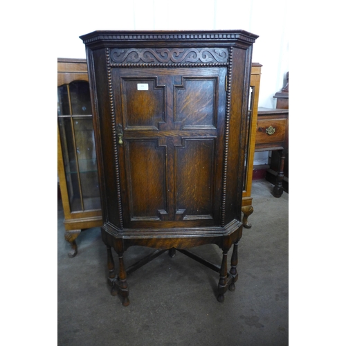 131 - A 17th Century style oak geometric moulded corner cupboard on stand