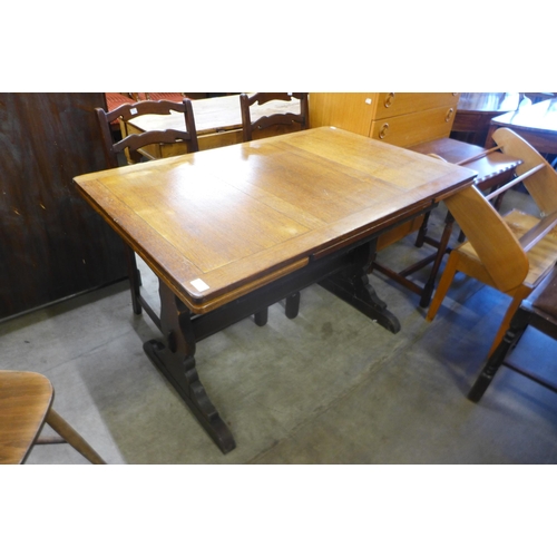 199 - An oak draw-leaf refectory table and three chairs