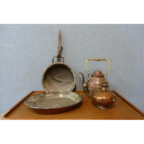 343 - An embossed copper armorial kettle, a small copper vase and two copper pans