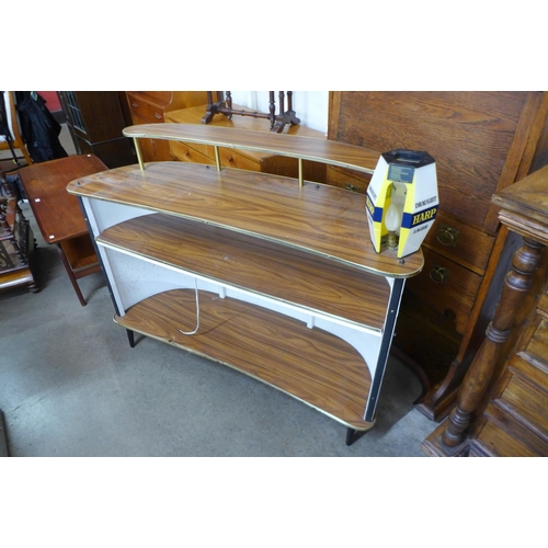 64B - A teak, brass and white vinyl boat shaped bar