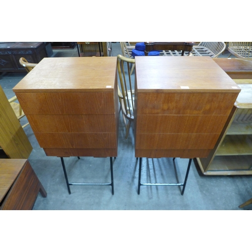 65 - A pair of teak three drawer chests on metal stands