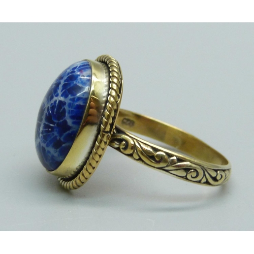 1028 - A silver gilt blue fossil coral cabochon ring, O