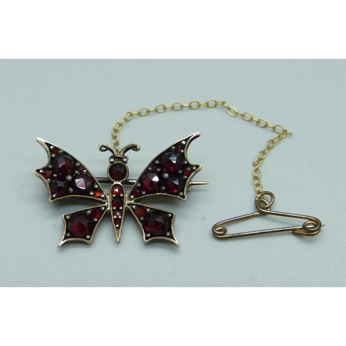 1033 - An antique garnet set butterfly brooch, 25mm wide