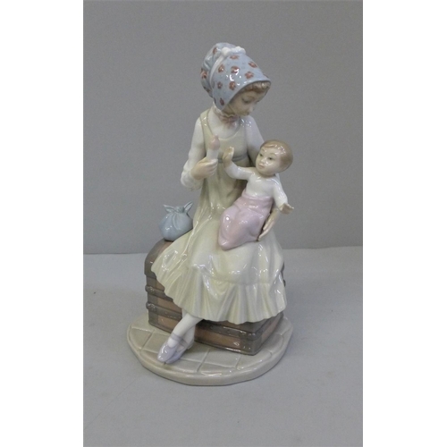 605 - A Lladro figure of a Mother feeding her baby, 23cm