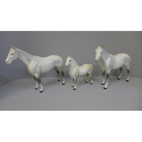 614 - Three Beswick dapple grey horses, smallest with one back leg restored and largest with one front leg... 