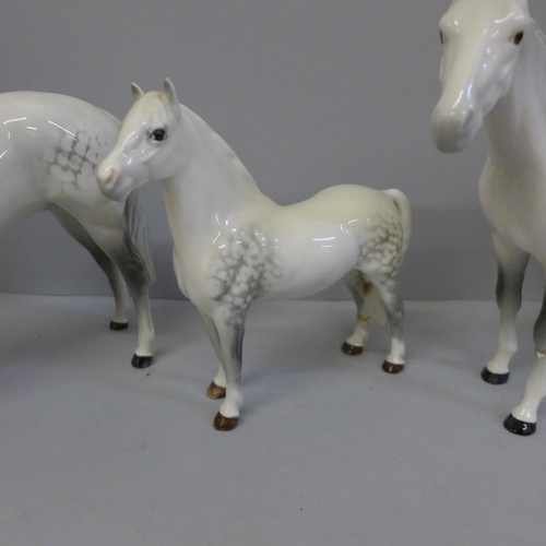 614 - Three Beswick dapple grey horses, smallest with one back leg restored and largest with one front leg... 