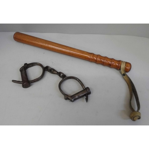 674 - A wooden truncheon and a pair of handcuffs