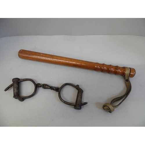 674 - A wooden truncheon and a pair of handcuffs