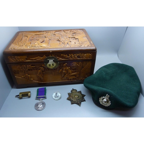 944 - A carved wooden box, a military beret with cap badge, other badges and a For Campaign Service medal ... 