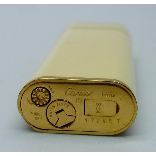 945 - A Cartier lighter in original box with spare Cartier flints