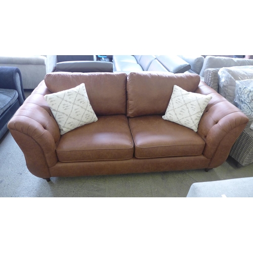 1560 - A dark tan vegan leather three seater sofa with patterned scatter cushions, damaged