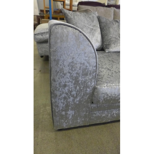 1586 - A silver crushed velvet three seater sofa and footstool