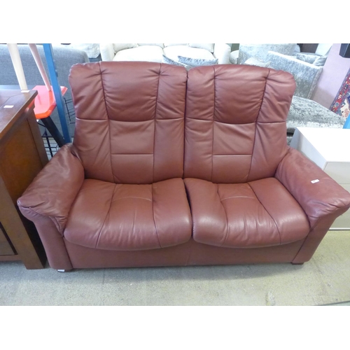 1615 - A red leather two seater push back reclining sofa