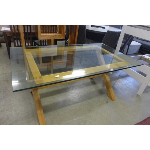 1620 - A glass topped dining table with oak x-frame base