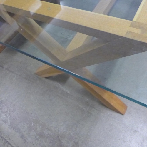 1620 - A glass topped dining table with oak x-frame base