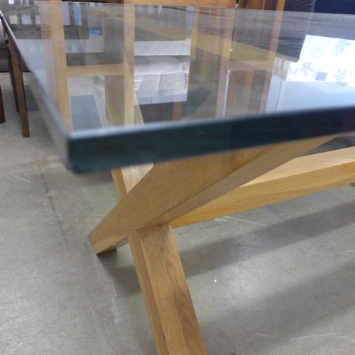 1620 - A glass topped dining table with oak x-frame base