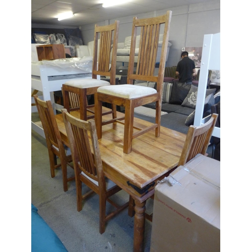 1622 - An Indian hardwood fixed top dining table with a set of six cream upholstered dining chairs