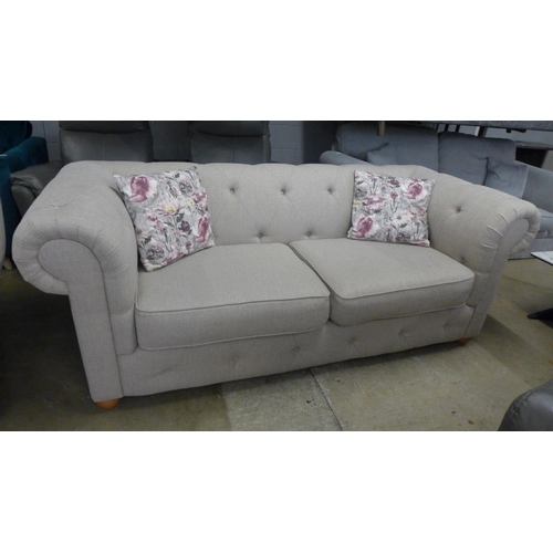 1442 - A taupe textured weave Chesterfield style three seater sofa and love seat with patterned scatter cus... 