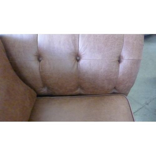 1560 - A dark tan vegan leather three seater sofa with patterned scatter cushions, damaged