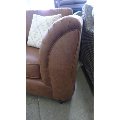 1560 - A dark tan vegan leather three seater sofa with patterned scatter cushions, damaged