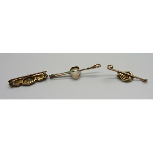 1026 - A 9ct gold and moonstone bar brooch, a 9ct gold brooch and a yellow metal brooch lacking pin, total ... 