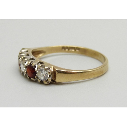 1055 - A 9ct gold ring set with garnets and white stones, 2g, P/Q