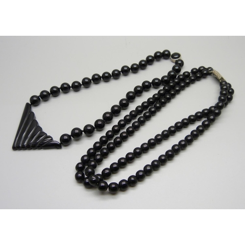 1072 - A black onyx necklace with silver clasp and another string of black beads