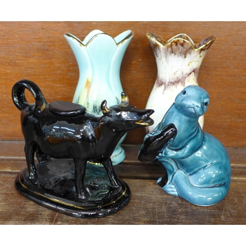 700 - A 19th century cow creamer, two 1950s vases, a Poole Pottery seal and an orange carnival glass bowl