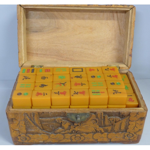 781 - An early 20th Century butterscotch Bakelite Mah Jong set in a carved wooden box