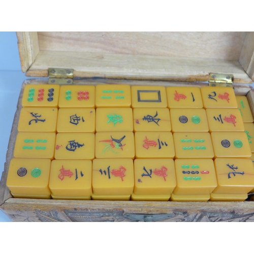 781 - An early 20th Century butterscotch Bakelite Mah Jong set in a carved wooden box